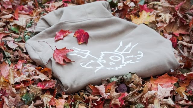 Folded tan hoodie showing the KTK skull and trident graphic